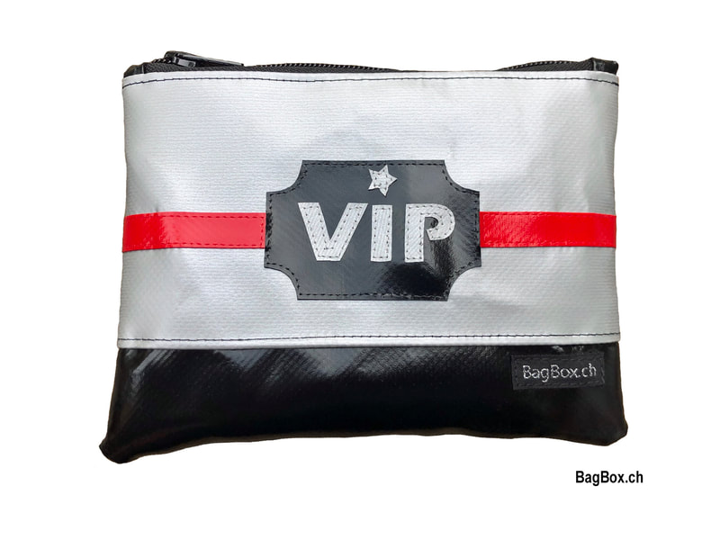 Reissverschlusstäschli mit "VIP" Schriftzug. In den Farben silber/ schwarz/ rot. 